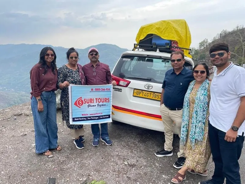 Suri Tours group with banner beside Innova Crysta during Chardham Yatra road trip