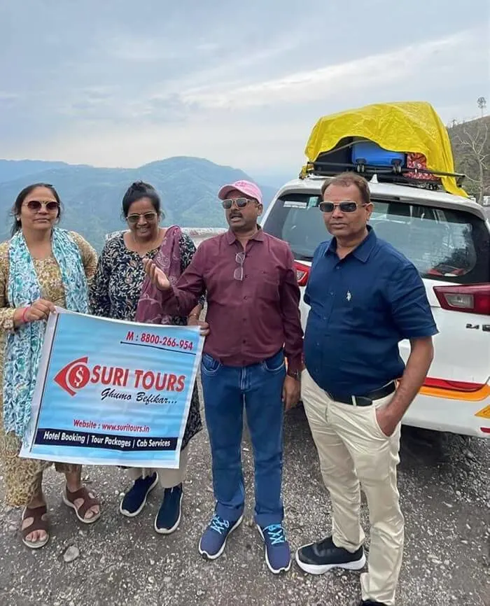 Suri Tours family group photo with Innova Crysta on a mountain trip