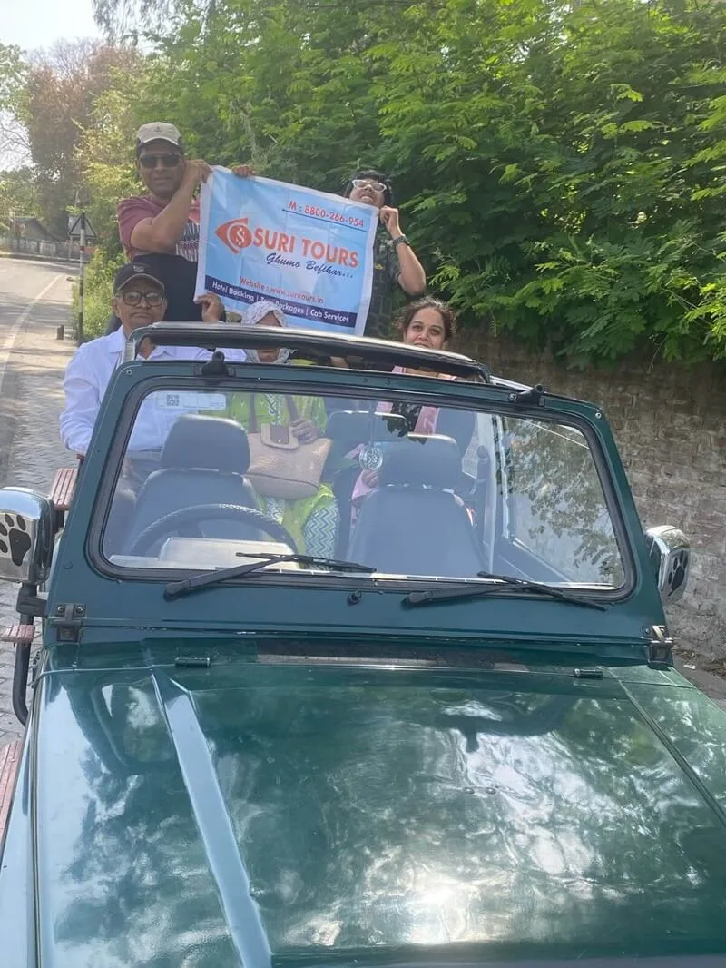 Suri Tours family enjoying an open jeep ride with banner